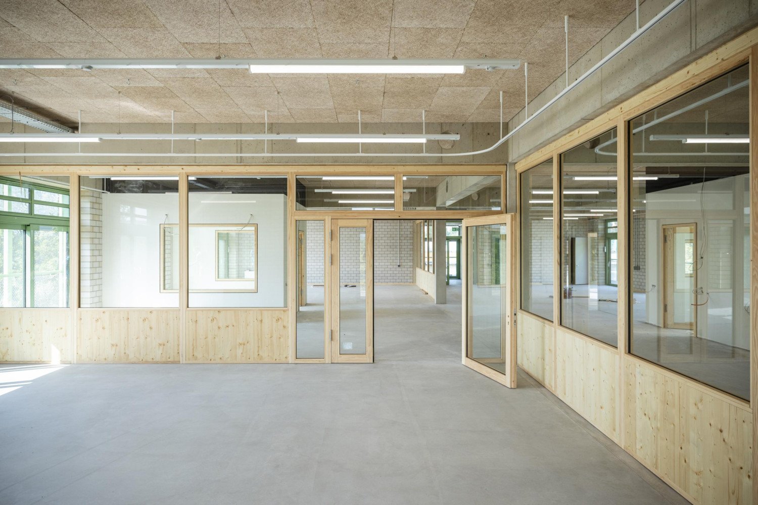 Helles, modernes Büro mit Holzverkleidung und großen Glasflächen, die eine offene Atmosphäre schaffen.