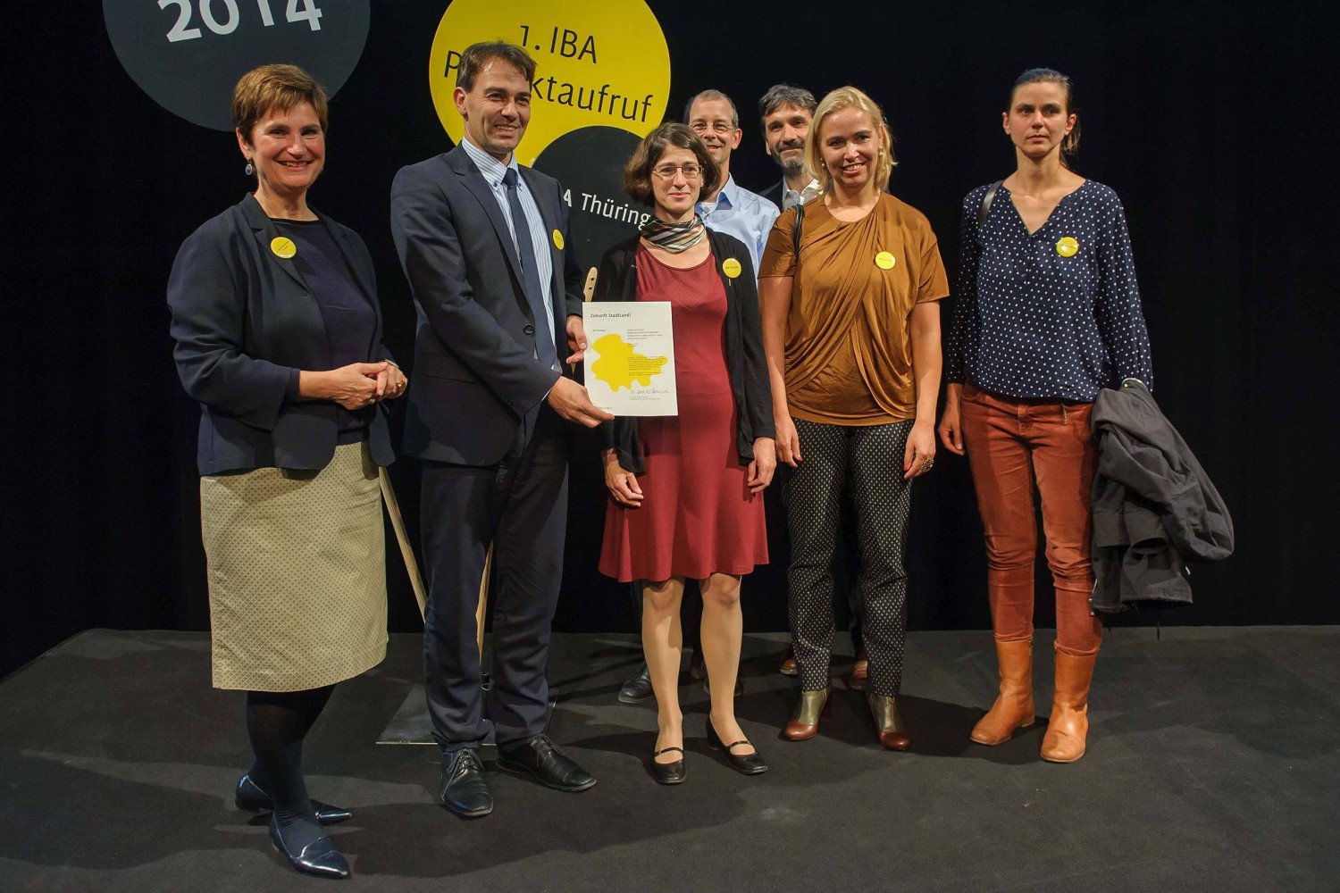 Dr. Marta Doehler-Behzadi, Geschäftsführerin der IBA Thüringen, Oberbürgermeister Peter Kleine und Vertreterinnen und Vertreter der Schule gemeinsam auf der Bühne.