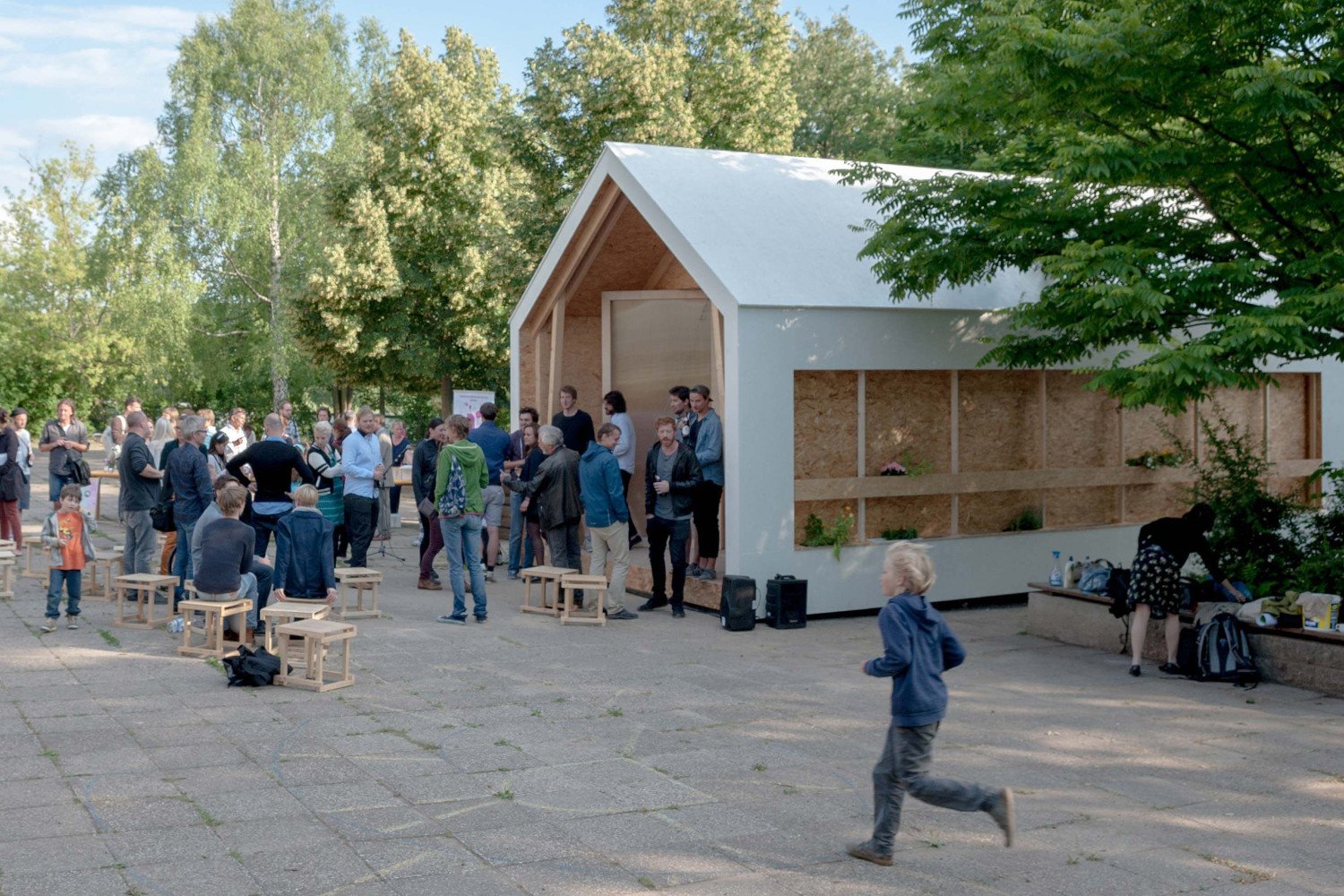 Menschengruppe vor dem IBA Pavillon auf dem Schulgrundstück.