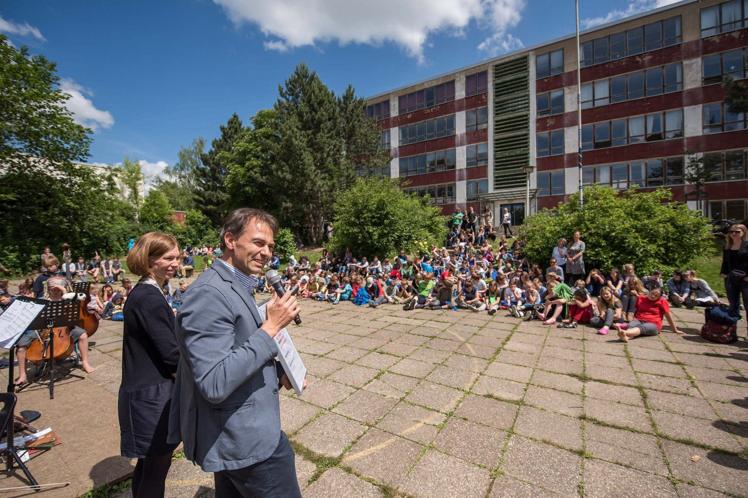Oberbürgermeister Peter Kleine und Barbara Pampe von der Montag Stiftung Jugend und Gesellschaft sprechen bei einer Kundgebung auf dem Schulgelände der Schule.